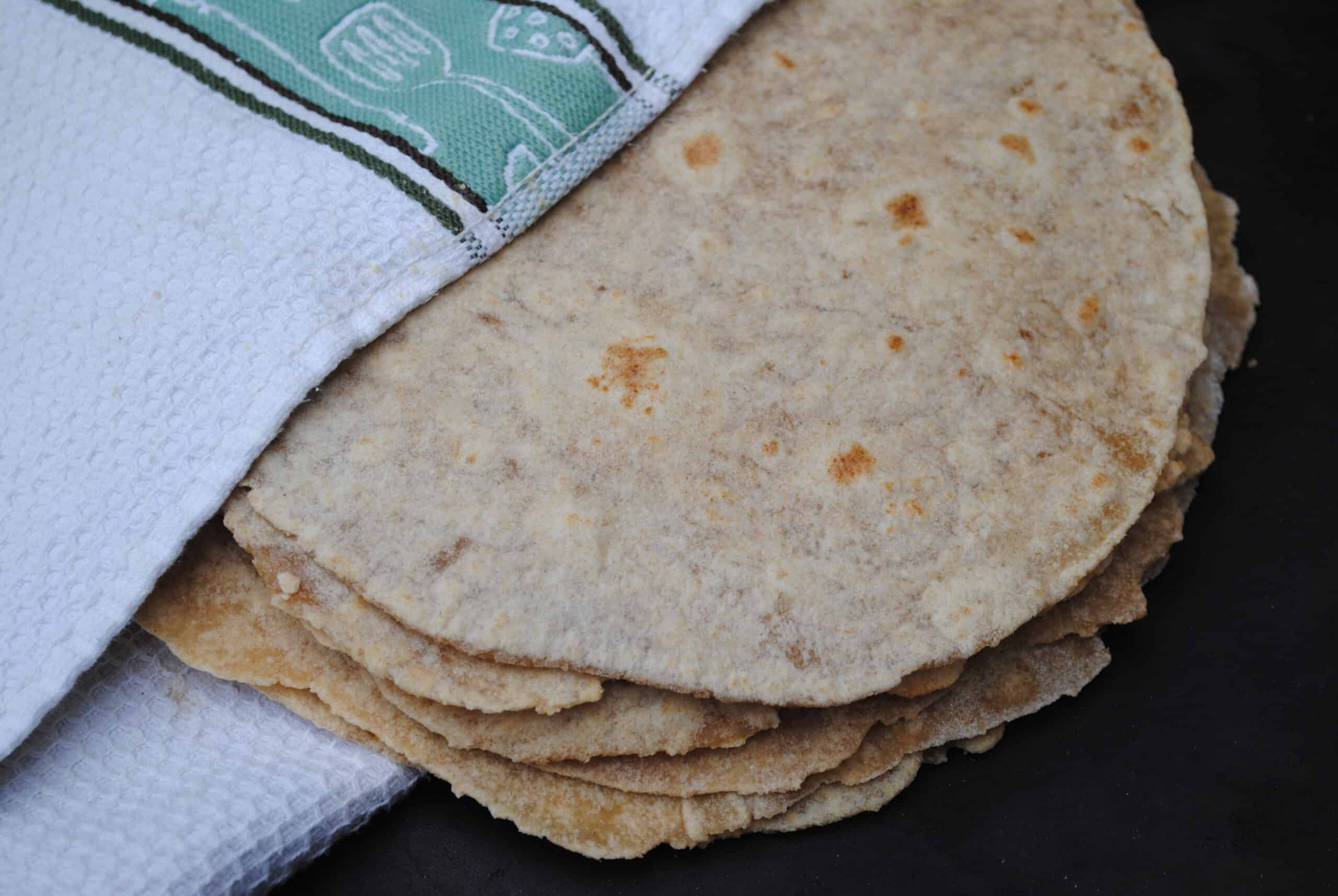 homemade whole wheat tortillas wrapped in a towel