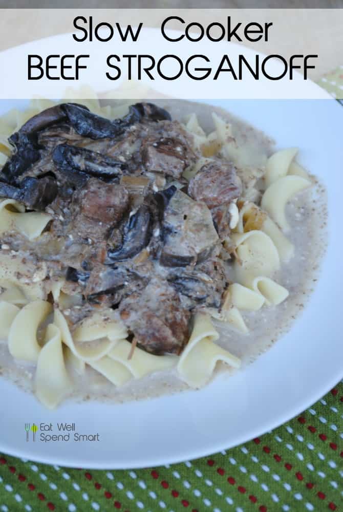 Beef stroganoff on a white plate beside a green towel