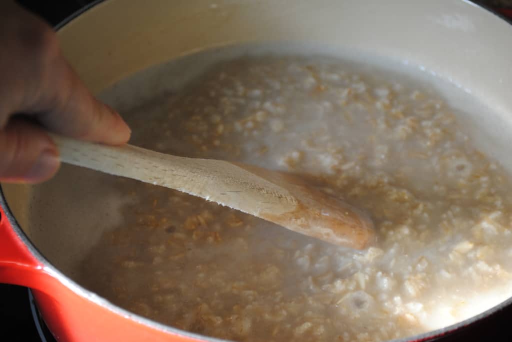 Premium Photo  Closeup of a person making oatmeal with milk in a pot on  the stove