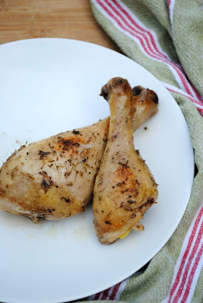 Two baked chicken legs on a plate.