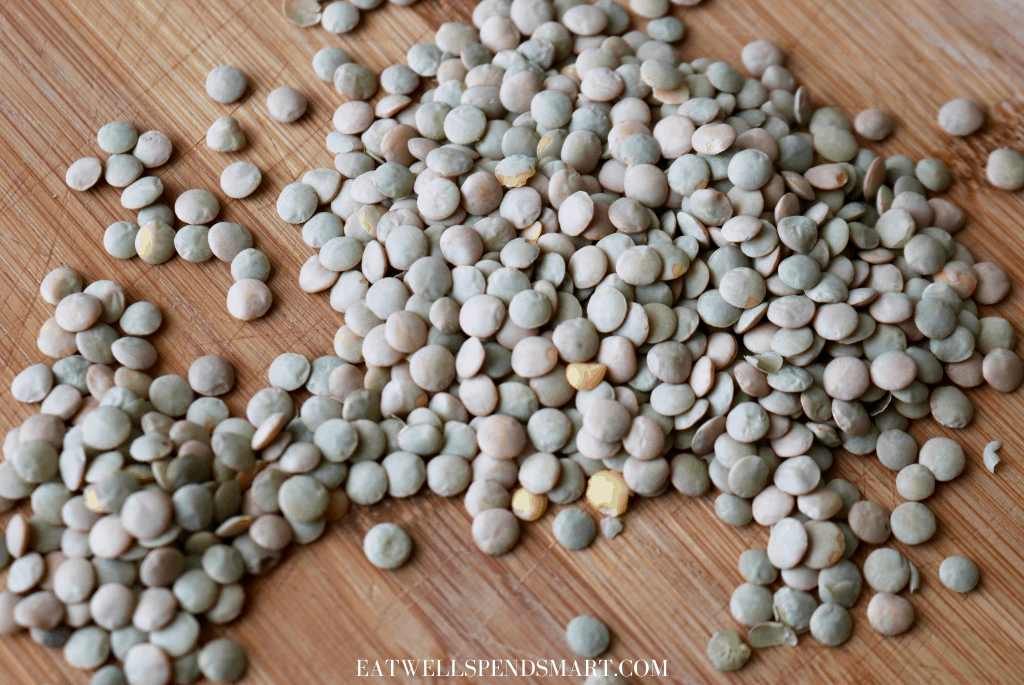 Green lentils scattered on a wooden board