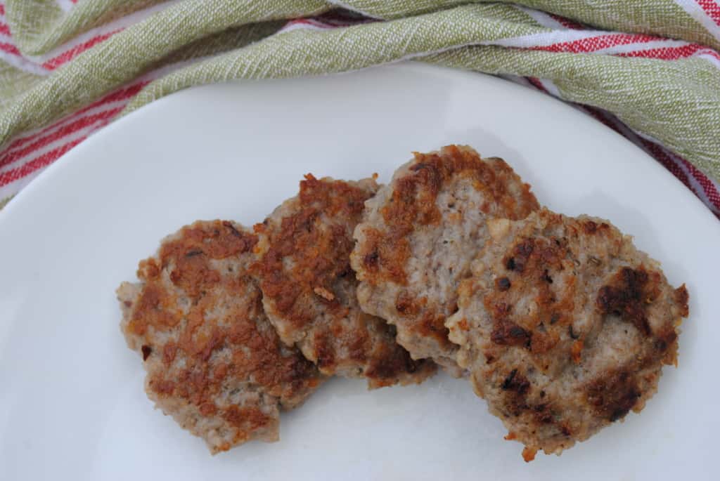 four sausage patties on a white plate