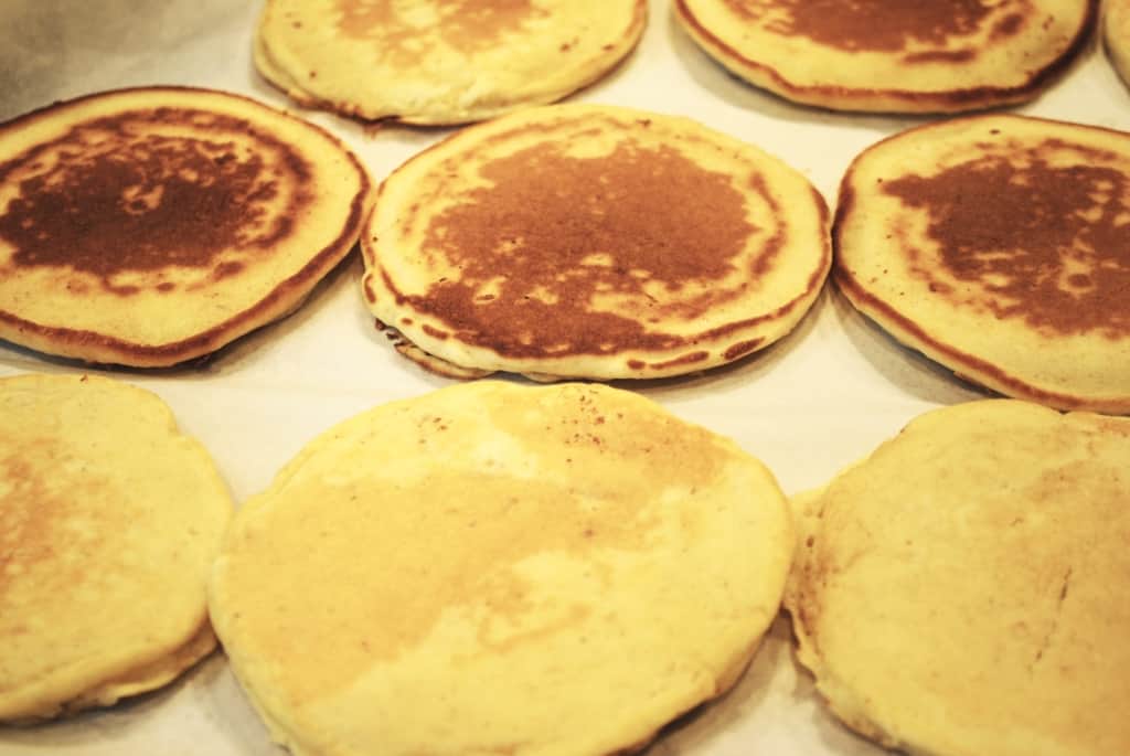 flash freezing pancakes flat in a single layer on a a parchment lined baking sheet