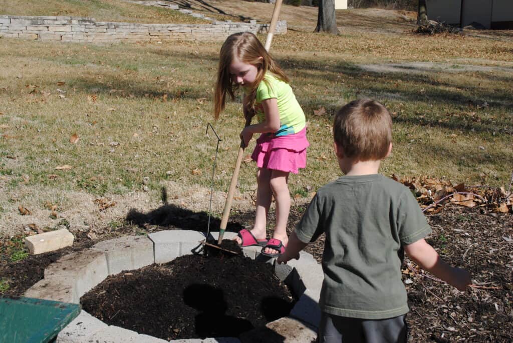 Girl spreading garden soil