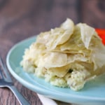 boiled cabbage on top of mashed potatoes on a light blue plate