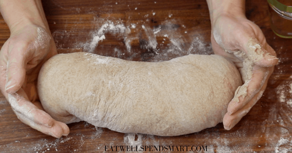 hands shaping whole wheat bread dough