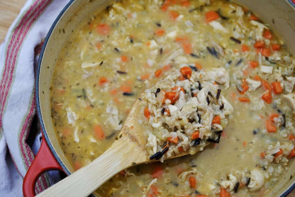 wooden spoon scooping a spoonful of chicken and wild rice soup