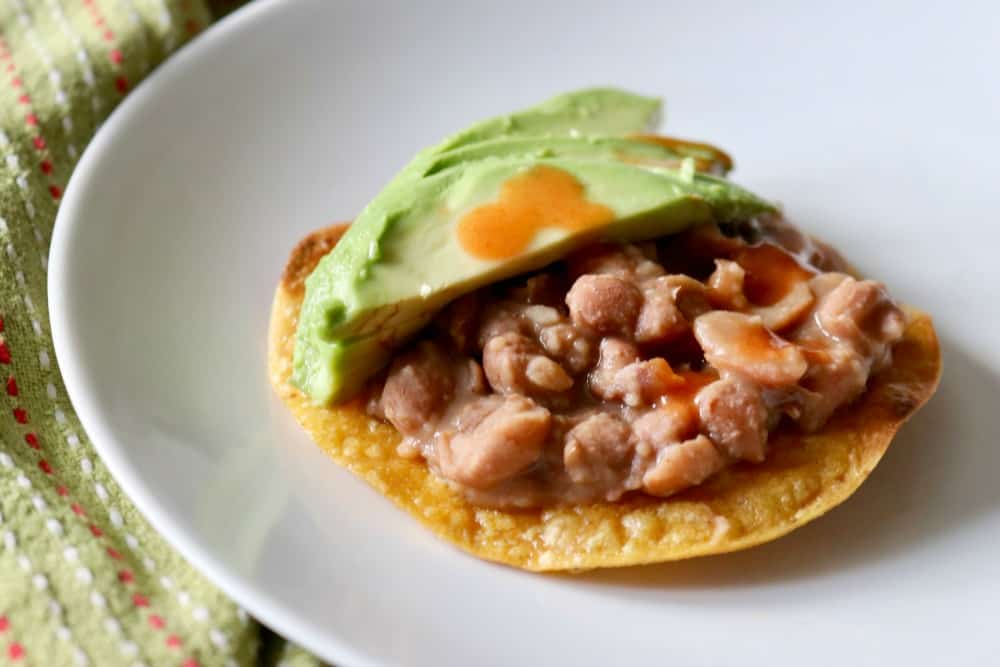 Leftover pinto beans on a crunchy corn tortilla