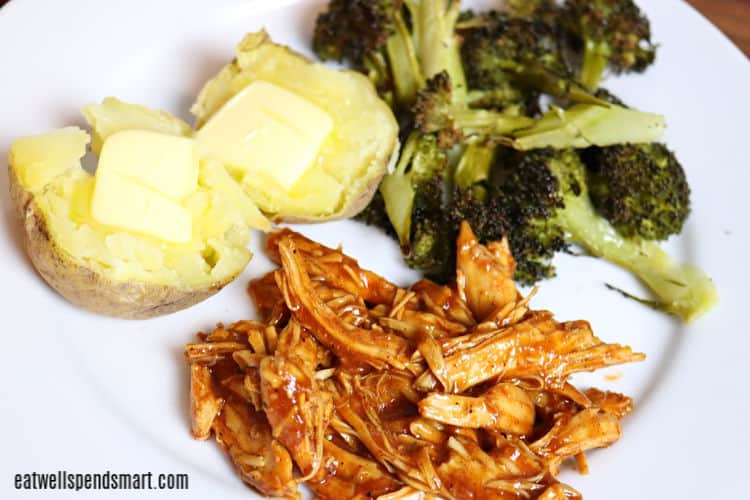 shredded bbq chicken, roasted broccoli, and baked potato with butter on a white plate