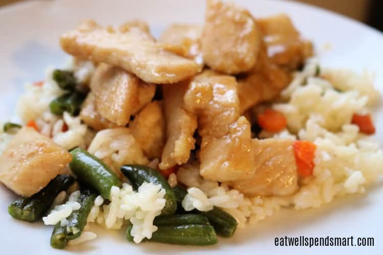 chicken teriyaki over vegetable fried rice on a white plate