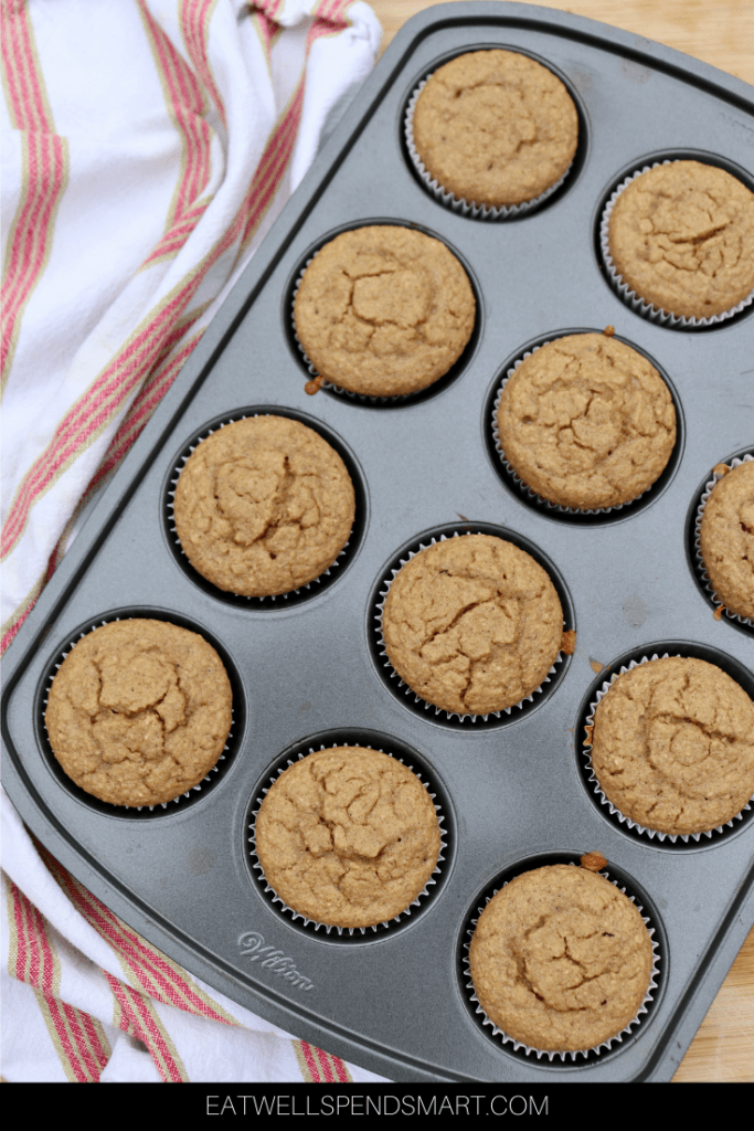 Muffins in a muffin tin with a striped towel 