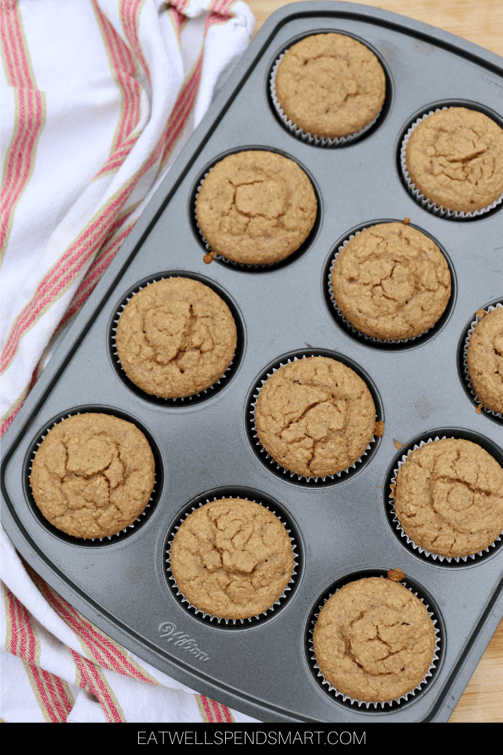 Muffins in a muffin tin with a striped towel