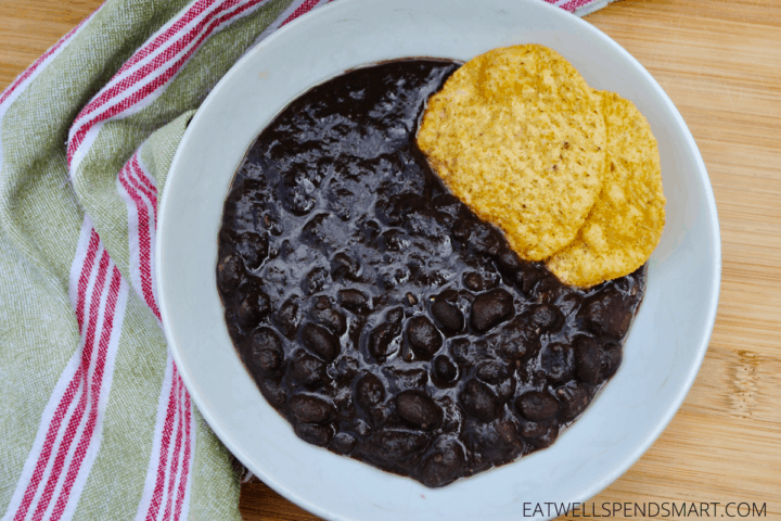 Cup of slow cooker black bean soup with tortilla chips