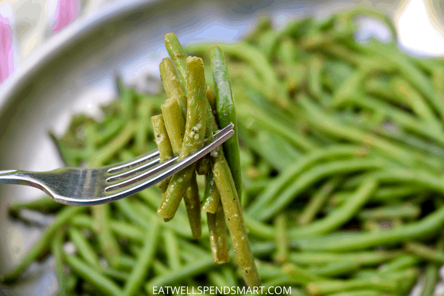 Cooked frozen green beans on a fork