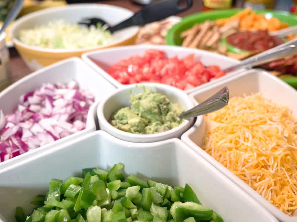 taco bar toppings in a white serving dish