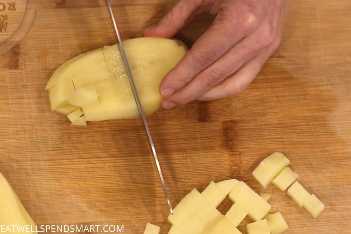 knife cutting potato into cubes