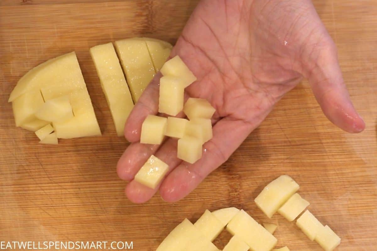 hand holding cubed potatoes