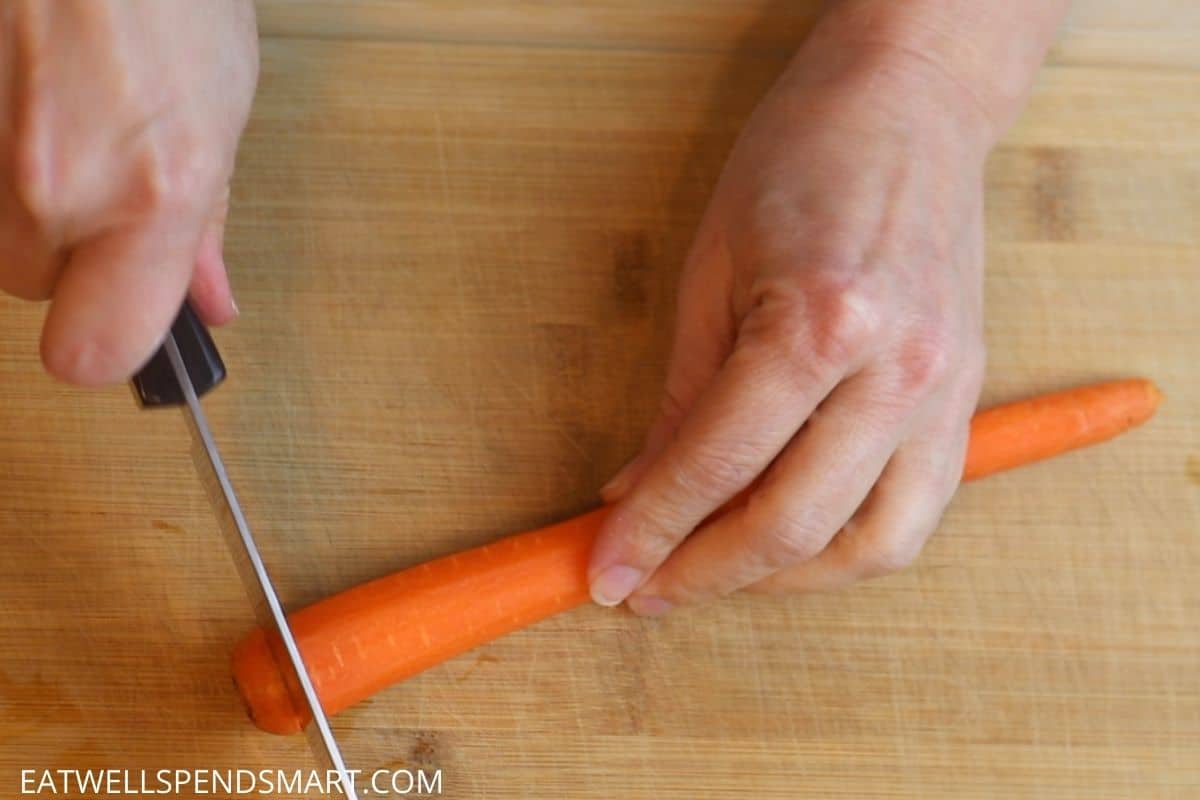 hand cutting then end off a carrot using a chef knife