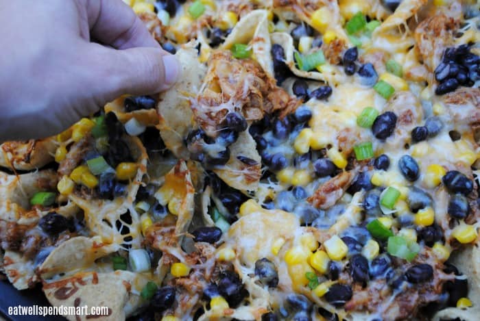 hand picking up a bite of bbq nachos