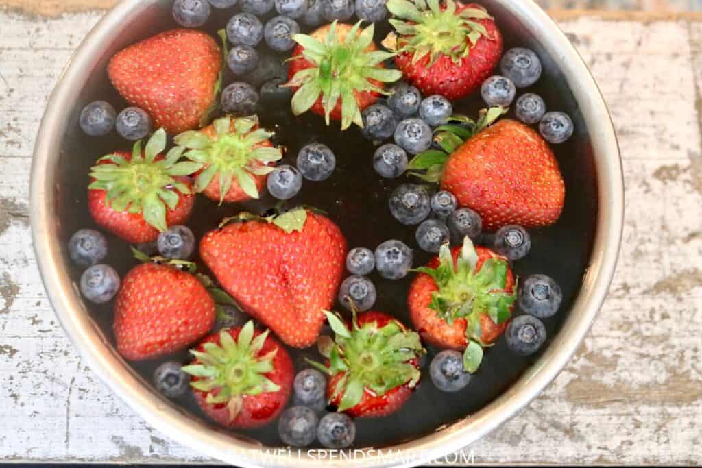 stawberries, blueberries, and blackberries soaking in vinegar water