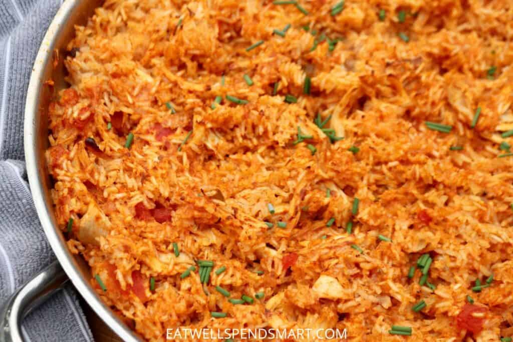 Spanish rice with chicken in a stainless steel skillet